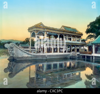 Vista colorata della barca in marmo sul lago Kunming al Palazzo Estivo, Pechino, Cina, 1901. Il padiglione si riflette nelle acque del lago artificiale. (Foto di Burton Holmes) Foto Stock