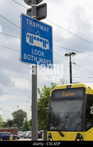 Attraversamento pedonale segno di avvertimento sul metrolink light railway/sistema tramviario di Manchester. Foto Stock