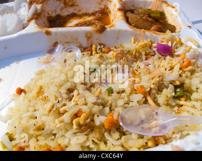 Cucchiaio, insalata e una piastra di plastica in un piatto indiano di Poha. Questo è un piatto a base di riso soffiato con verdure tagliate e dip. Foto Stock