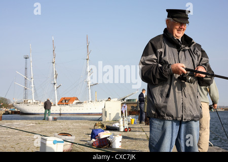 Stralsund, pescatori nel porto di fronte all'addestramento alla vela di nave Gorch Fock Foto Stock