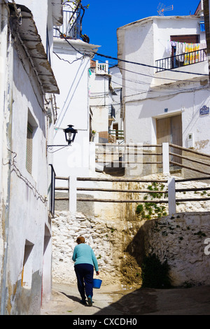 La donna a piedi attraverso una corsia imbiancate di Laroles village di Las Alpujarras. Granada, Andalusia, Spagna Foto Stock