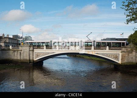 Tram LUAS sul Sean Heuston ponte sopra il fiume Liffey, Dublino, Irlanda. Foto Stock