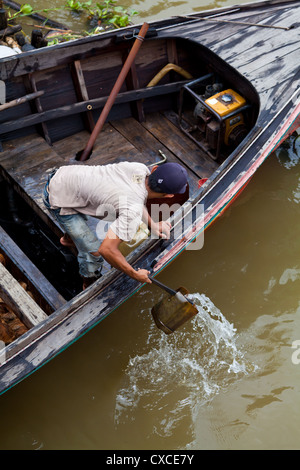 Uomo al lavoro su un battello fluviale in Banjarmasin in Indonesia Foto Stock