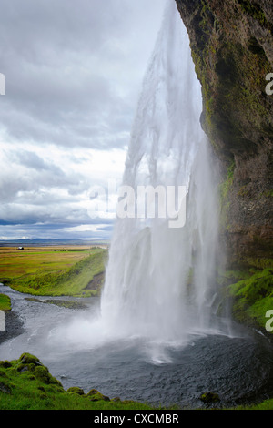 Seljalandsfoss presi da dietro la cascata, Sud Islanda Foto Stock