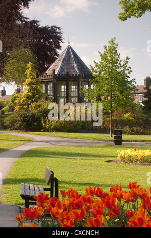 Bellissimo villaggio paesaggistico parco con aiuole fiorite, ordinato prato & gazebo storico (casa rotonda) - Grange Park, il Burley in Wharfedale, Inghilterra. Foto Stock