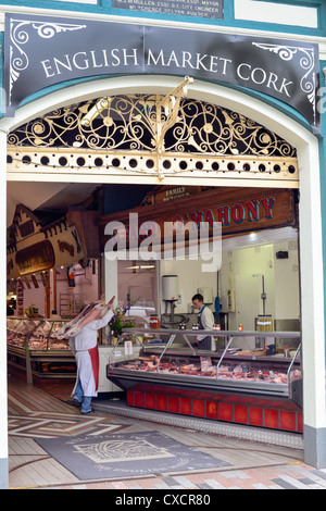 Un macellaio con un intero sopra la sua spalla al mercato inglese, la città di Cork, Repubblica di Irlanda. Foto Stock
