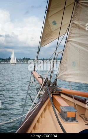 La storica tall ship schooner Zodiac visto sfilare sulla prua di un'altra imbarcazione a vela durante una gara di Bellingham Bay, Washington. Foto Stock