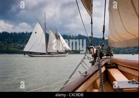 La storica tall ship schooner Zodiac visto sfilare sulla prua di un'altra imbarcazione a vela durante una gara di Bellingham Bay, Washington. Foto Stock