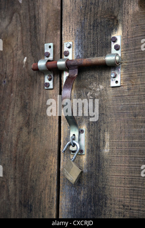 Si tratta di una foto di una chiusura o di una parte di una parete o porta fare di manufatti in legno vecchio board.possiamo vedere una maniglia della porta con una serratura Foto Stock
