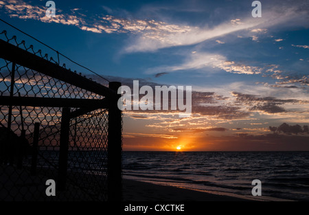 La silhouette di una recinzione al tramonto a Bill's Beach, Coral Bay Foto Stock