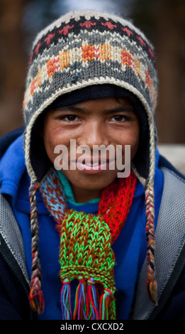 Ritratto di un ragazzo nepalese che indossa un cappello colorato e sciarpa, Nepal Foto Stock