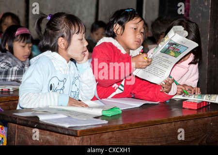 Myanmar Birmania, Kalaw. Scuola elementare e in classe i bambini birmani. Le ragazze di lettura. Foto Stock