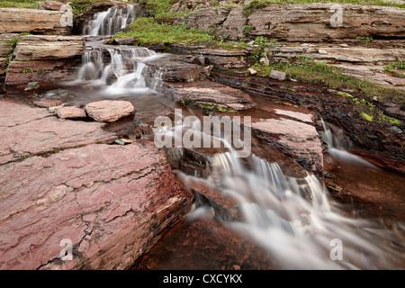 Cascades su roccia rossa, il Parco Nazionale di Glacier, Montana, Stati Uniti d'America, America del Nord Foto Stock