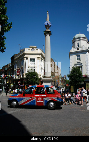 Londra taxi in giro per il Seven Dials meridiana un monumento nel mezzo di Seven Dials, Covent Garden di Londra, Regno Unito Foto Stock