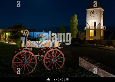 Vecchio carrello in legno, la torre dell orologio e la luce della luna sul mare a Nana beach resort Agios Nikolaos Creta Grecia Foto Stock