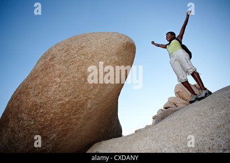 Donna escursionismo su rocce di grandi dimensioni Foto Stock