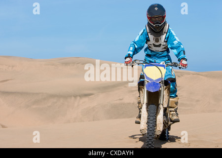 Adolescente cilena in sella motocicletta sulla duna di sabbia Foto Stock