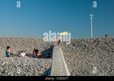 Un giovane ragazzo sventolando un asciugamano sulla spiaggia di Dieppe Francia Foto Stock