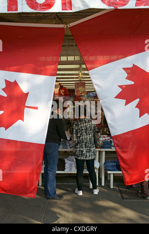 Shoppers incorniciata da una coppia di bandiere canadesi, Chinatown, Vancouver, British Columbia, Canada Foto Stock
