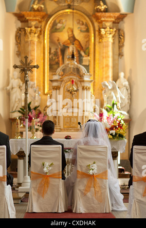 Lo sposo e la sposa alla cerimonia di matrimonio in chiesa Foto Stock