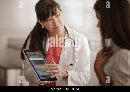 Medico mostra digitale compressa al paziente Foto Stock