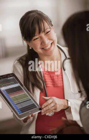 Medico mostra digitale compressa al paziente Foto Stock