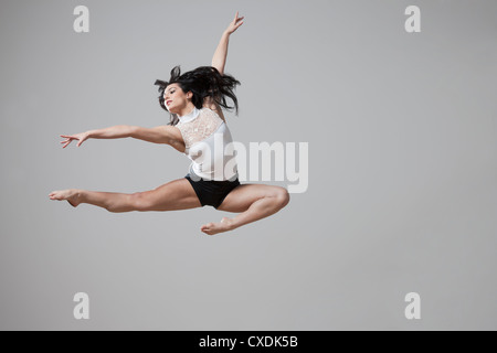 Grazioso Caucasian ballerina in mid-air Foto Stock