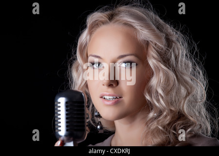 Bella giovane donna con microfono Foto Stock