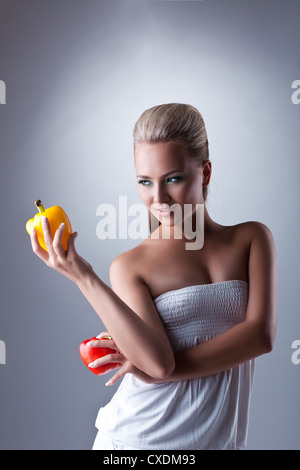 Piuttosto giovane donna tenere due pepe bulgaro Foto Stock