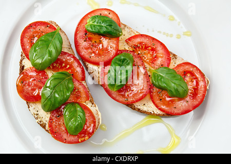 Delizioso pane con pomodoro e basilico e olio di oliva Foto Stock