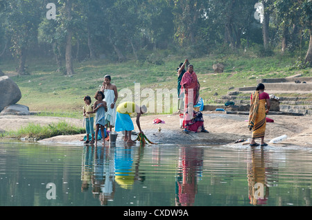 Le donne a lavare i panni sul ghats del Fiume Mahanadi, riflessa nell'acqua, Orissa, India, Asia Foto Stock