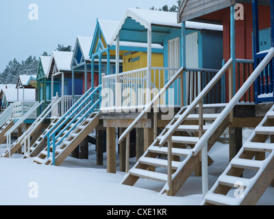 Cabine sulla spiaggia, nella neve a Wells accanto al mare, Norfolk, Inghilterra Foto Stock