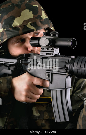Soldato armato tenendo obiettivo Foto Stock