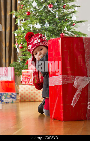 Baby girl sbirciare gran regalo di Natale Foto Stock