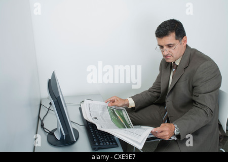 Imprenditore leggendo il giornale in ufficio Foto Stock