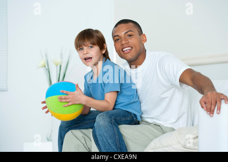 Figlio seduto sul padre di giro Foto Stock