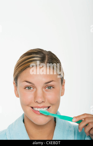Giovane donna spazzolare i suoi denti Foto Stock