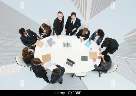 I dirigenti aziendali incontro sulla parte superiore dell'immagine sovrapposta di grattacieli Foto Stock