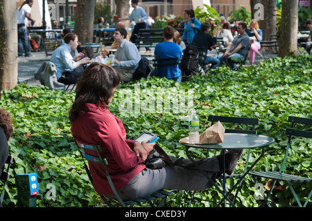 Un lettore utilizza il suo Amazon Kindle libro elettronico in Bryant Park di New York Foto Stock