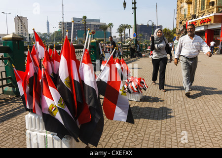 L uomo e la donna velata a piedi dall'Egitto bandiere in vendita in piazza Tahrir al Cairo, Egitto Foto Stock