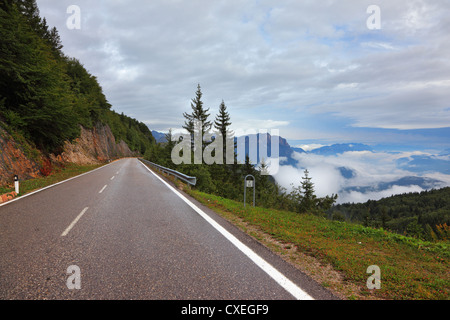 Strada bagnata nella Svizzera, bassa cumulus nubi Foto Stock