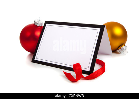 Un fustellato notecard circondata da un nastro rosso e un rosso e oro ornamento di Natale su sfondo bianco Foto Stock