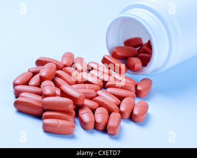 Red pillole fuoriuscire dalla bottiglia Foto Stock