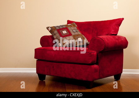 Sedia rossa su un pavimento di legno Foto Stock