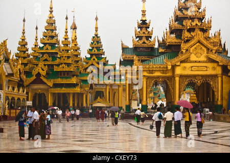 Di birmani con ombrelloni a Shwedagon Paya o pagoda che risale al 1485 - YANGON, MYANAMAR Foto Stock