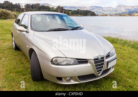 Color Champagne l'Alfa Romeo 156 Sportwagon, parcheggiata accanto al porto di Akaroa in Nuova Zelanda. Foto Stock