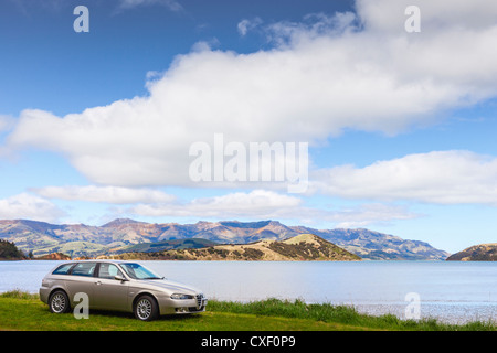Color Champagne l'Alfa Romeo 156 Sportwagon, parcheggiata accanto al porto di Akaroa in Nuova Zelanda. Foto Stock