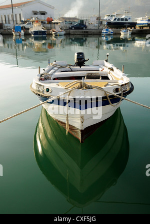 Le riflessioni di un blu e bianco barca Foto Stock