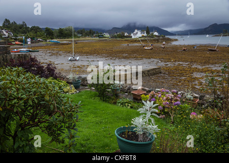 Giardino che si affaccia sul tidal flats di Plockton Bay, Loch Carron, Wester Ross, Scozia Foto Stock