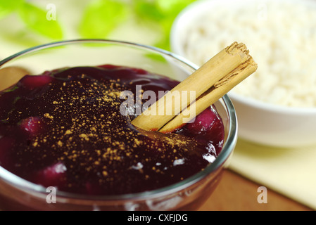 Dessert peruviano chiamato Mazamorra Morada fatta di mais porpora e condito con cannella con budino di riso nella parte posteriore Foto Stock